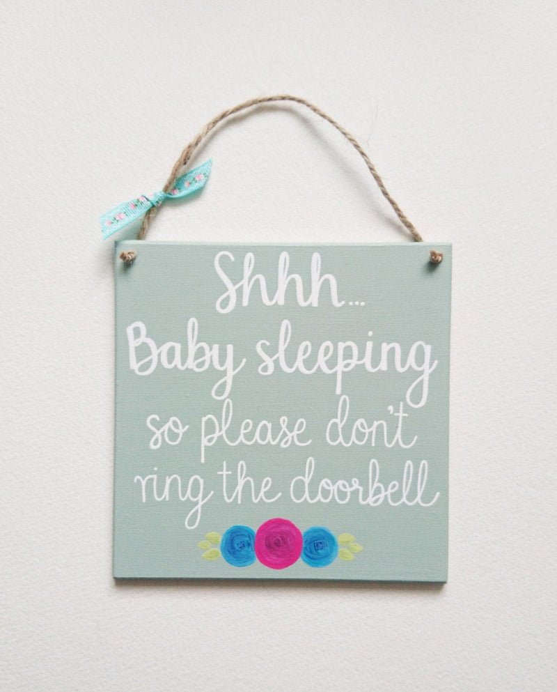 Hand painted with the words: Shhh... Baby sleeping so please don't ring the doorbell  Complete with hanging rope and a little ribbon, perfect for a newborn baby gift.